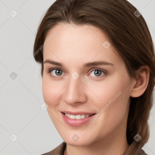 Joyful white young-adult female with medium  brown hair and grey eyes