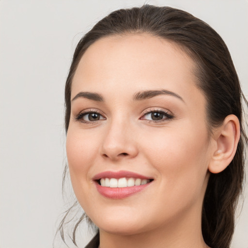 Joyful white young-adult female with long  brown hair and brown eyes