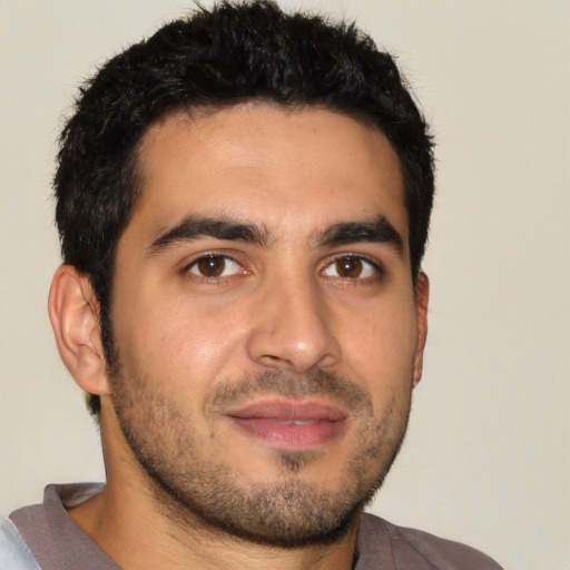 Joyful latino young-adult male with short  brown hair and brown eyes