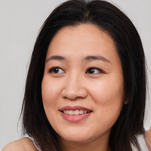 Joyful asian young-adult female with long  brown hair and brown eyes