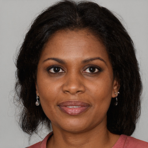 Joyful black adult female with medium  brown hair and brown eyes