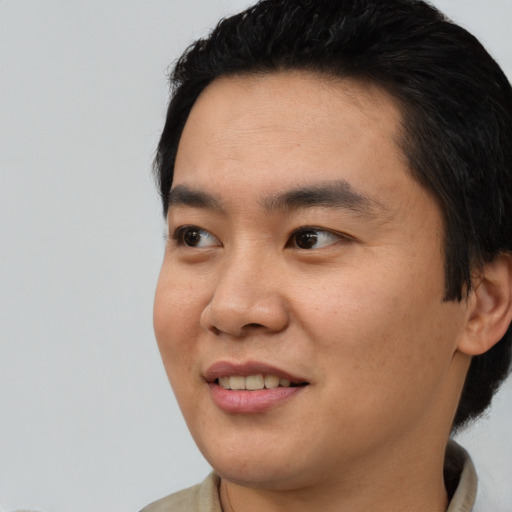 Joyful asian young-adult male with short  black hair and brown eyes