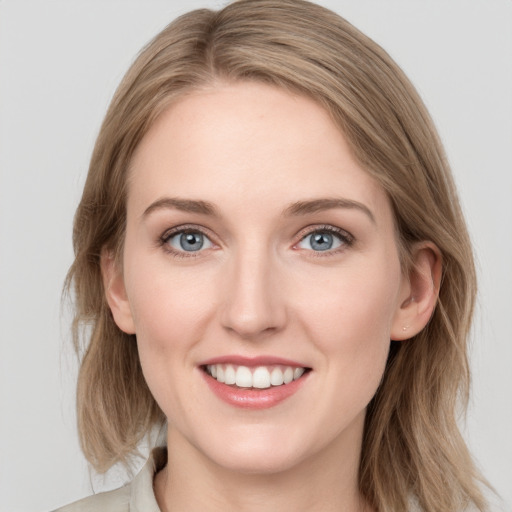 Joyful white young-adult female with medium  brown hair and blue eyes