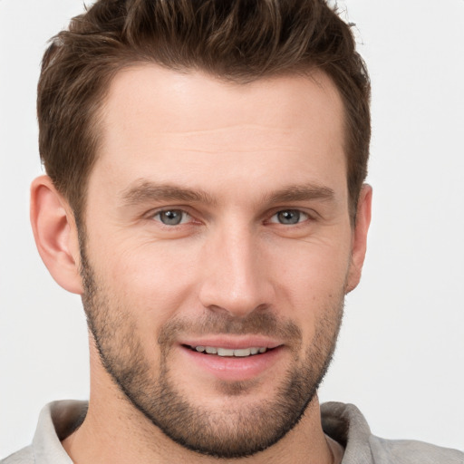 Joyful white young-adult male with short  brown hair and grey eyes