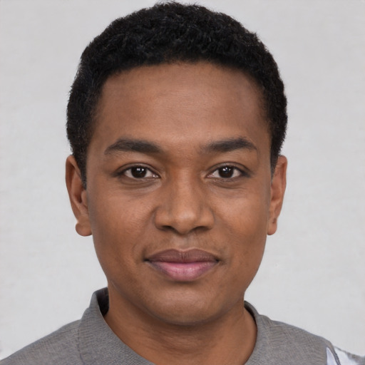 Joyful black young-adult male with short  black hair and brown eyes