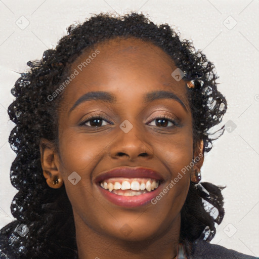 Joyful black young-adult female with long  brown hair and brown eyes