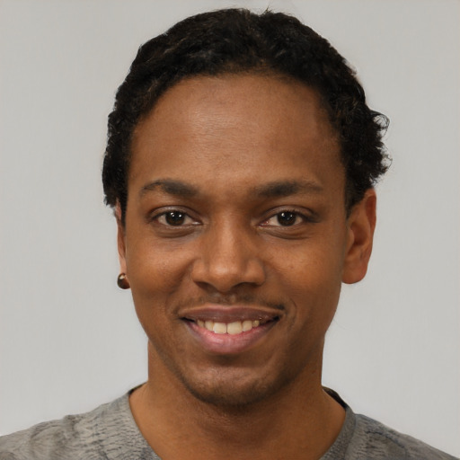 Joyful black young-adult male with short  black hair and brown eyes