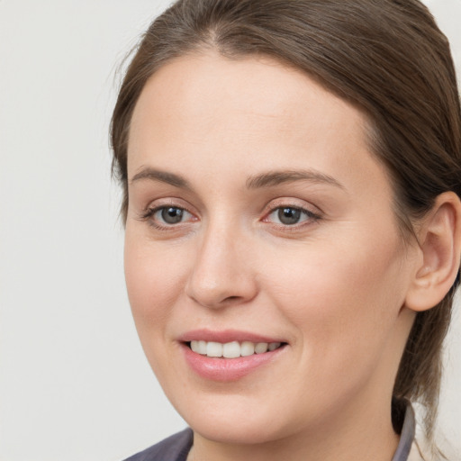 Joyful white young-adult female with medium  brown hair and grey eyes