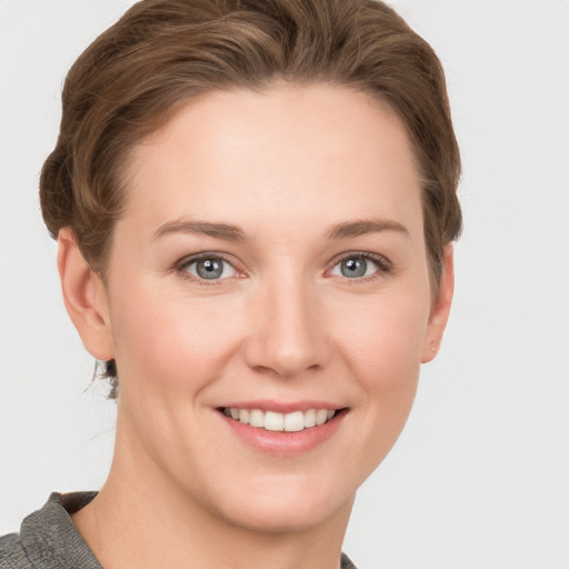 Joyful white young-adult female with short  brown hair and grey eyes