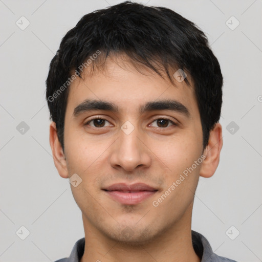 Joyful latino young-adult male with short  black hair and brown eyes