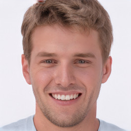 Joyful white young-adult male with short  brown hair and grey eyes