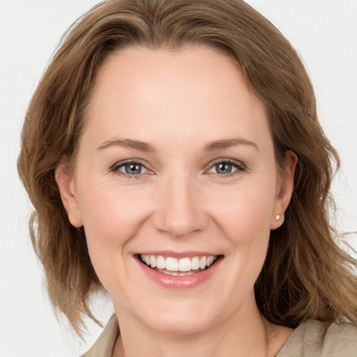 Joyful white young-adult female with medium  brown hair and grey eyes