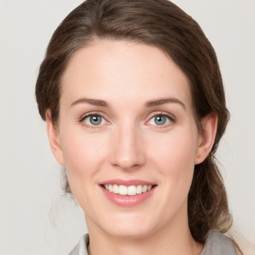 Joyful white young-adult female with medium  brown hair and green eyes