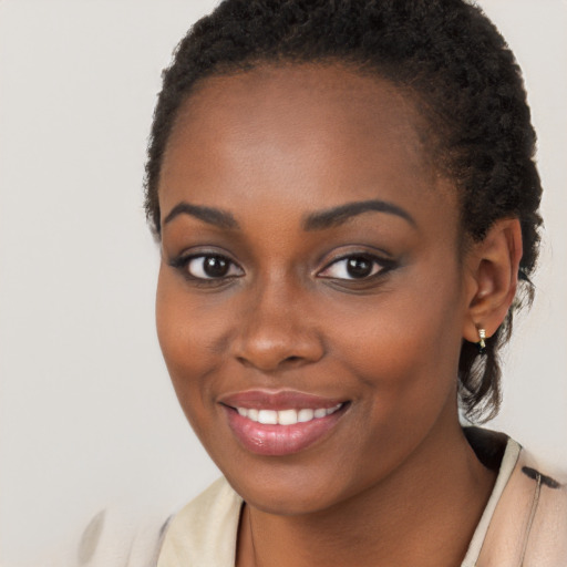 Joyful black young-adult female with long  brown hair and brown eyes