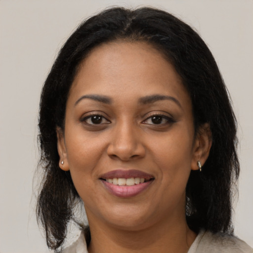 Joyful black young-adult female with medium  brown hair and brown eyes