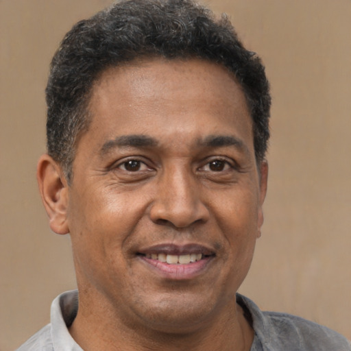 Joyful latino adult male with short  brown hair and brown eyes