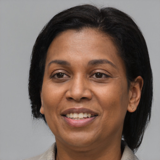 Joyful latino adult female with medium  brown hair and brown eyes