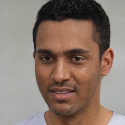 Joyful white young-adult male with short  black hair and brown eyes