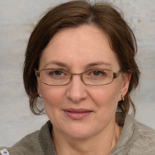 Joyful white adult female with medium  brown hair and blue eyes