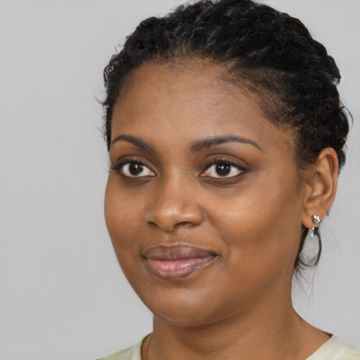 Joyful black young-adult female with short  brown hair and brown eyes