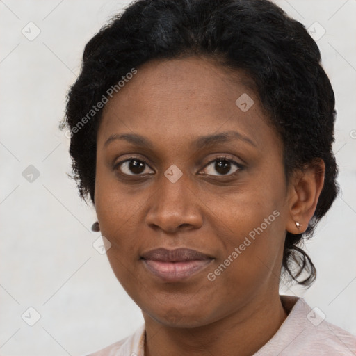 Joyful black adult female with short  black hair and brown eyes