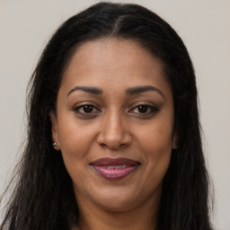 Joyful black adult female with long  brown hair and brown eyes