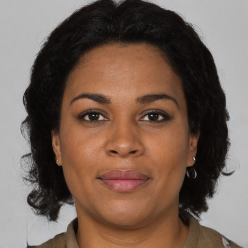 Joyful black adult female with medium  brown hair and brown eyes