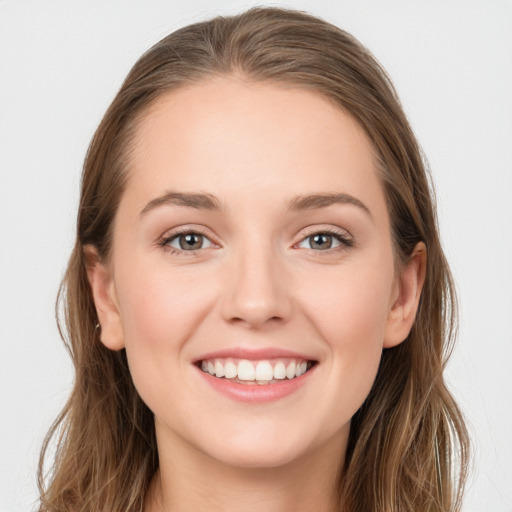 Joyful white young-adult female with long  brown hair and blue eyes