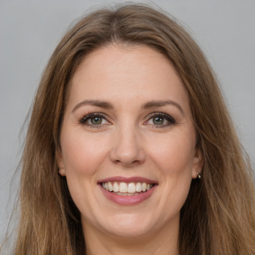 Joyful white young-adult female with long  brown hair and green eyes