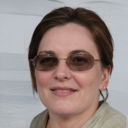 Joyful white young-adult female with medium  brown hair and blue eyes