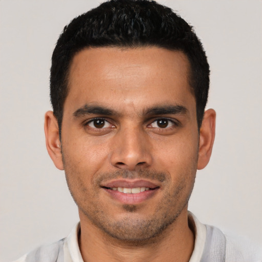 Joyful white young-adult male with short  black hair and brown eyes