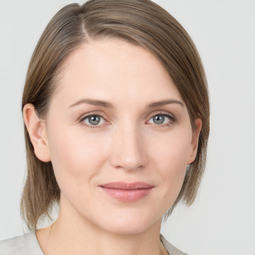 Joyful white young-adult female with medium  brown hair and grey eyes