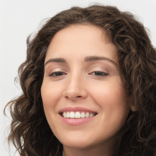 Joyful white young-adult female with long  brown hair and green eyes