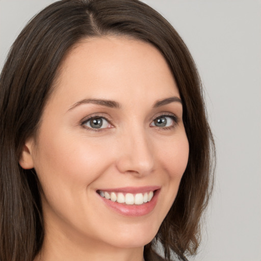 Joyful white young-adult female with long  brown hair and brown eyes