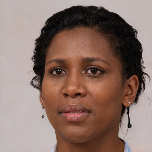 Joyful black young-adult female with medium  brown hair and brown eyes