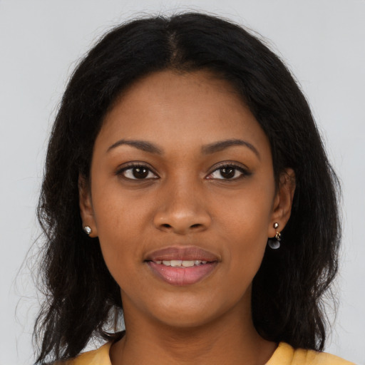 Joyful black young-adult female with long  brown hair and brown eyes