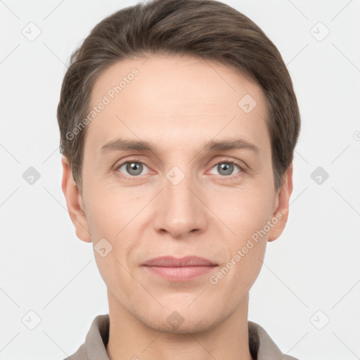 Joyful white young-adult male with short  brown hair and grey eyes