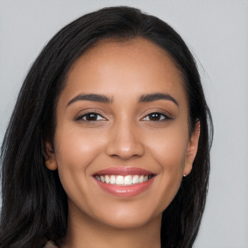 Joyful latino young-adult female with long  brown hair and brown eyes