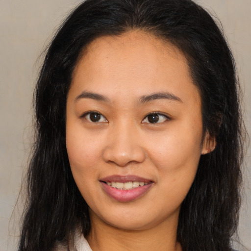 Joyful asian young-adult female with long  brown hair and brown eyes