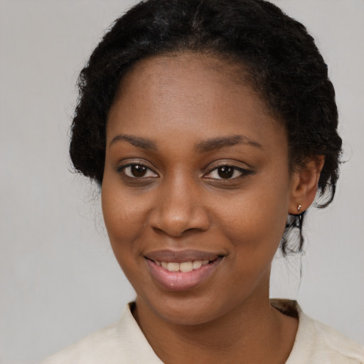 Joyful black young-adult female with long  brown hair and brown eyes