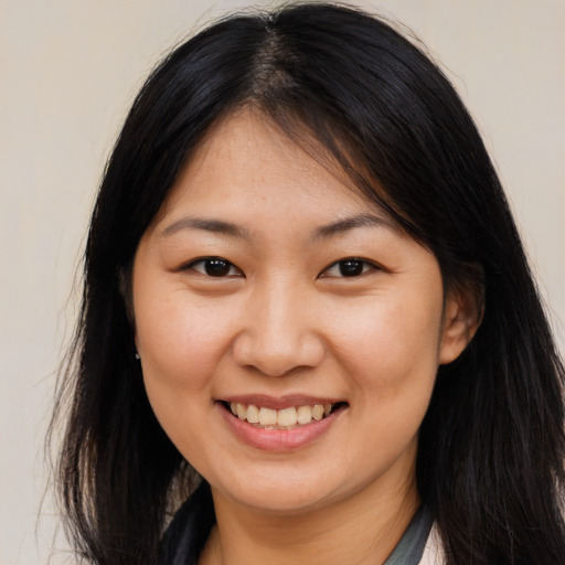 Joyful asian young-adult female with long  brown hair and brown eyes