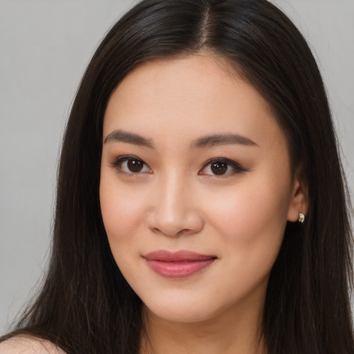 Joyful asian young-adult female with long  brown hair and brown eyes