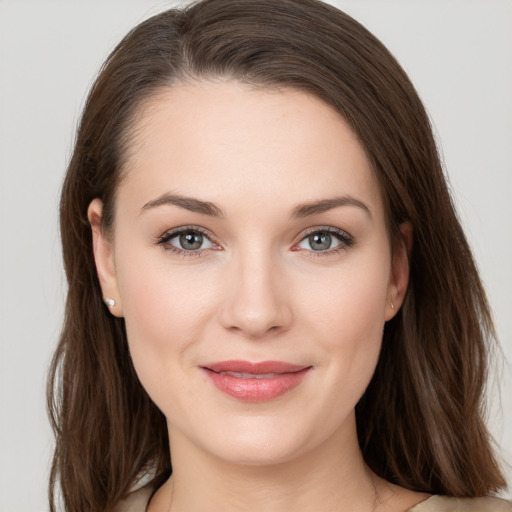 Joyful white young-adult female with long  brown hair and brown eyes