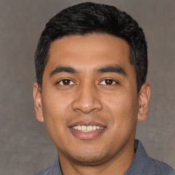 Joyful latino young-adult male with short  black hair and brown eyes