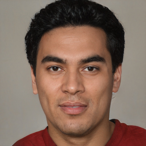 Joyful latino young-adult male with short  black hair and brown eyes