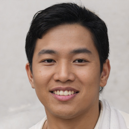 Joyful asian young-adult male with short  black hair and brown eyes