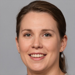 Joyful white adult female with medium  brown hair and grey eyes