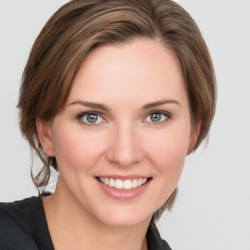 Joyful white young-adult female with medium  brown hair and grey eyes