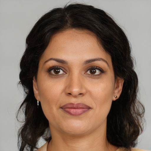Joyful latino adult female with medium  brown hair and brown eyes