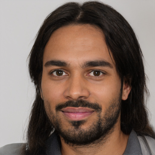 Joyful latino young-adult male with medium  brown hair and brown eyes